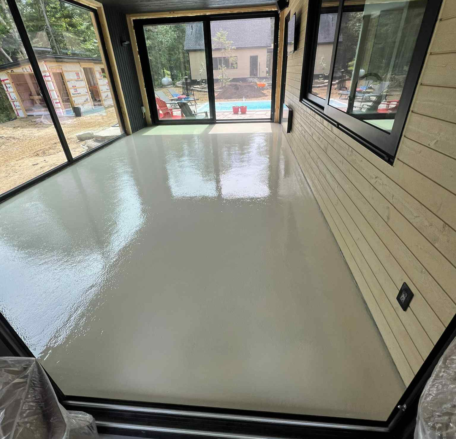 Plancher en époxy beige appliqué dans une pièce résidentielle, offrant une finition durable et facile d’entretien  à Sainte-Sophie